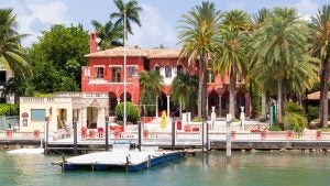 lakeside house with palm trees and dock